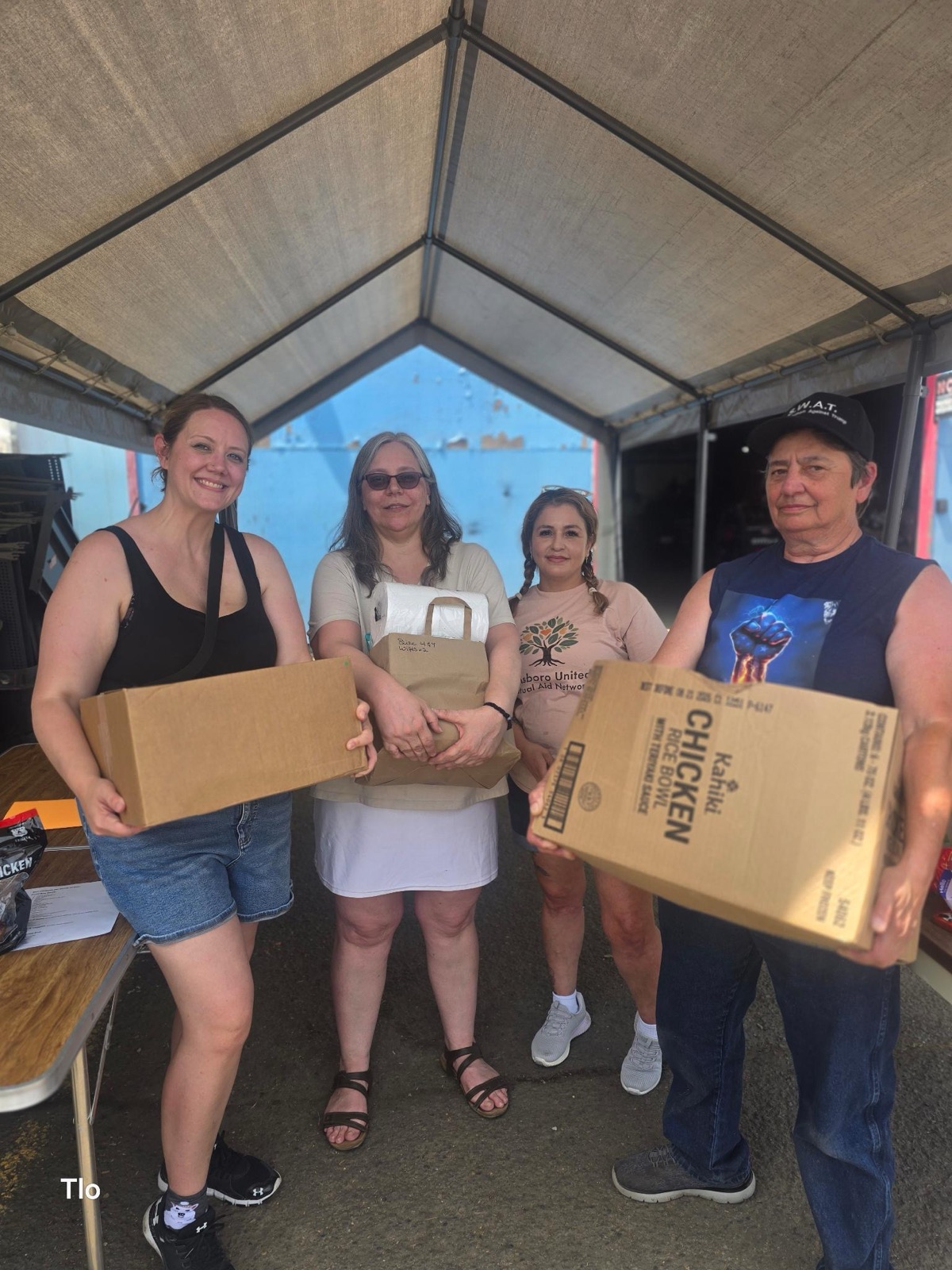 Volunteers holding boxes of food at a distribution event